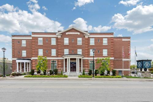 um grande edifício de tijolos ao lado de uma rua em The Champlain Waterfront Hotel Ascend Hotel Collection em Orillia