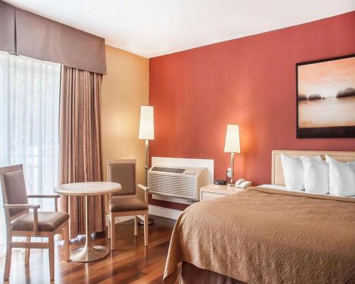 a hotel room with a bed and a table and chairs at Quality Hotel Fallsview Cascade in Niagara Falls