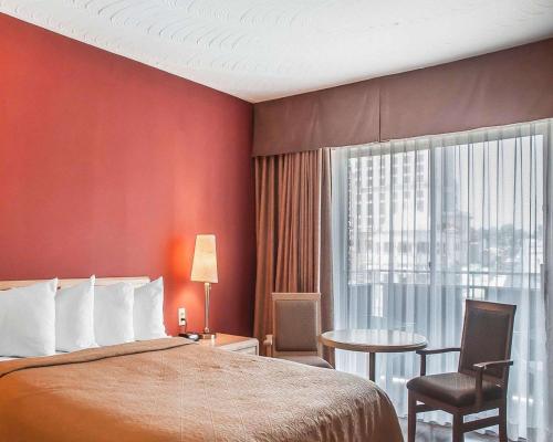 a hotel room with a bed and a window at Quality Hotel Fallsview Cascade in Niagara Falls