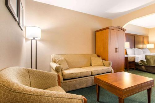 a living room with a couch and a table and a bed at Comfort Inn & Suites Shawinigan in Shawinigan