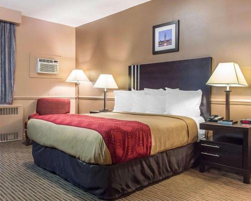 a hotel room with a large bed and a chair at Econo Lodge Downtown Ottawa in Ottawa