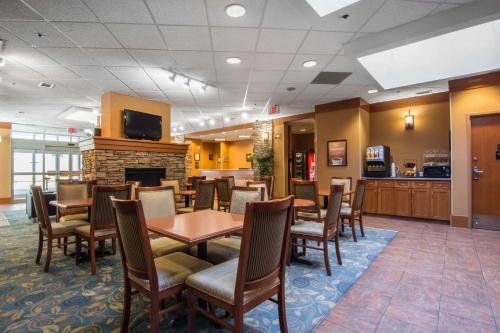 uma sala de jantar com mesas e cadeiras e uma lareira em Econo Lodge Inn & Suites University em Calgary