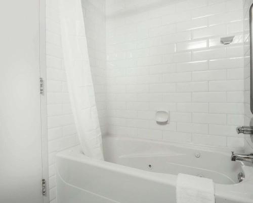 biała łazienka z wanną i umywalką w obiekcie Quality Hotel Airport - South w mieście Richmond