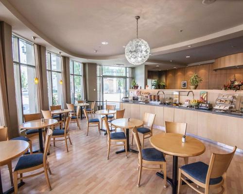 a restaurant with tables and chairs and a kitchen at Comfort Hotel Vancouver Airport in Richmond