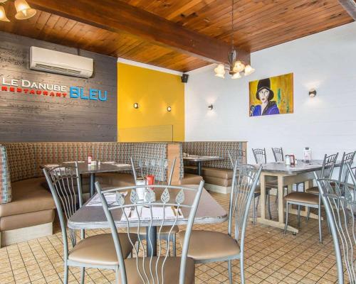 a dining room with tables and chairs in a restaurant at Hotel Danube Bleu in Forestville