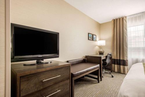 a hotel room with a flat screen tv and a bedroom at Comfort Inn & Suites in Red Deer
