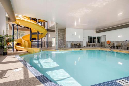 a large swimming pool with a slide in a building at Comfort Inn & Suites Red Deer in Red Deer