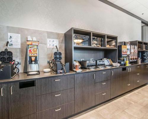 een keuken met bruine kasten en een aanrecht bij Quality Suites in Drummondville