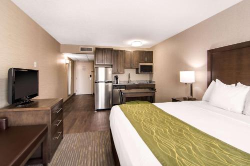 a hotel room with a bed and a kitchen at Comfort Inn & Suites in Red Deer