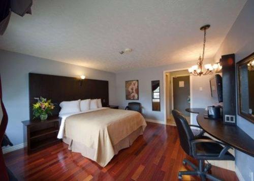 a hotel room with a bed and a desk at Quality Hotel Fallsview Cascade in Niagara Falls