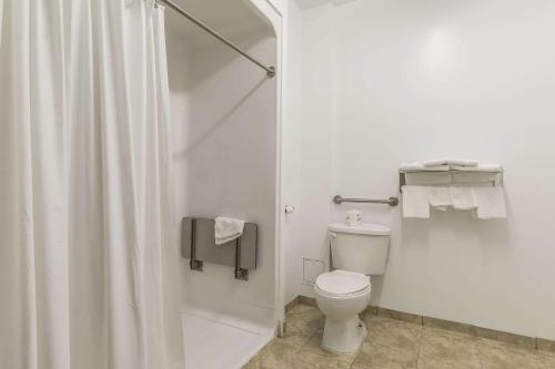 uma casa de banho branca com um chuveiro e um WC. em Econolodge Huntsville em Huntsville