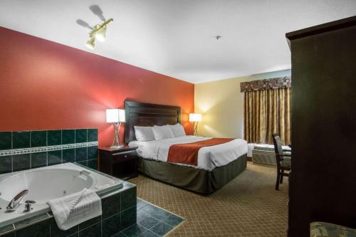 a hotel room with a bed and a bath tub at Comfort Inn & Suites Airport South in Calgary