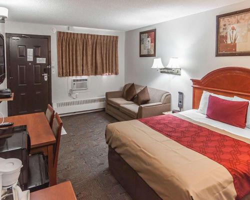 a hotel room with a bed and a couch at Econo Lodge Inn & Suites Drumheller in Drumheller