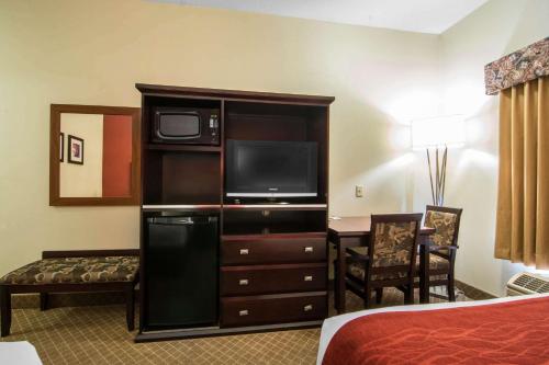 a hotel room with a tv on a entertainment center at Comfort Inn & Suites Airport South in Calgary