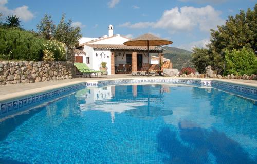 a swimming pool in front of a house at Cortijo Lagarín in El Gastor