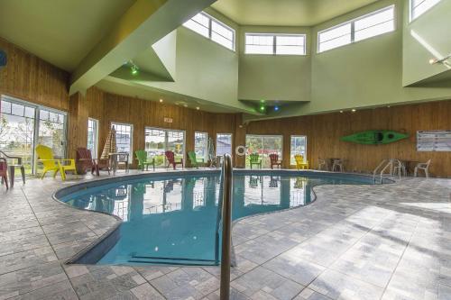a swimming pool in a large building with windows at Quality Inn in Rivière-du-Loup