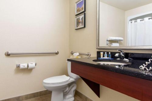 a bathroom with a toilet and a sink with a mirror at Comfort Inn & Suites in Lévis