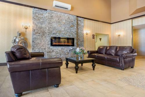 a living room with two leather couches and a fireplace at Comfort Inn & Suites in Lévis