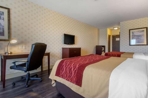 a hotel room with a bed and a desk and a chair at Comfort Inn & Suites in Lévis