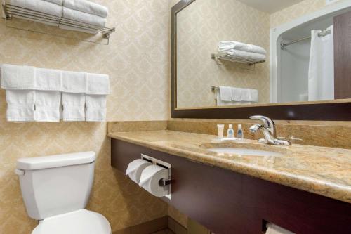 a bathroom with a toilet and a sink and a mirror at Comfort Inn & Suites in Lévis