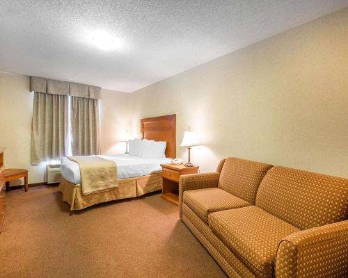 a hotel room with a bed and a couch at Quality Inn & Suites Lethbridge in Lethbridge