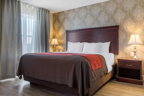 a hotel room with a bed and a window at Comfort Inn & Suites in Lévis