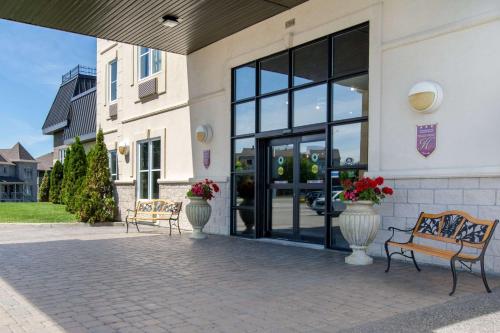 two benches in front of a building with windows at Comfort Inn & Suites in Lévis