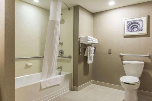 a bathroom with a toilet and a tub and a shower at Quattro Hotel & Conf. Centre, Ascend Hotel Collection in Sault Ste. Marie