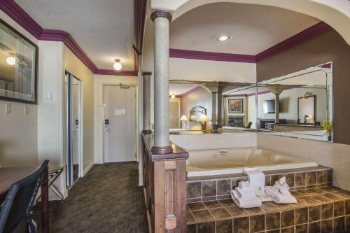 a large bathroom with a tub with a large mirror at Quality Inn & Suites High Level in High Level