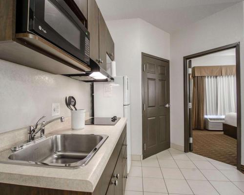 a kitchen with a sink and a microwave at Quality Inn & Suites in Estevan