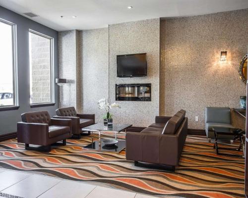 a lobby with couches and a tv on a wall at Comfort Hotel Bayer's Lake in Halifax