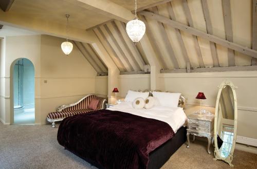 a bedroom with a large bed and a couch at The Spread Eagle Hotel in Thame