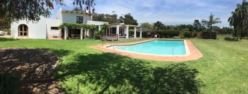 a large yard with a swimming pool in front of a house at Blue Skies Country House in Lorraine