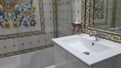 La salle de bains est pourvue d'un lavabo blanc et d'un miroir. dans l'établissement Lx Art Flats | Flat One, à Lisbonne