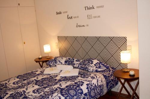Schlafzimmer mit einem Bett mit blauer und weißer Bettwäsche in der Unterkunft Casino Figueira Prime Apartment in Figueira da Foz