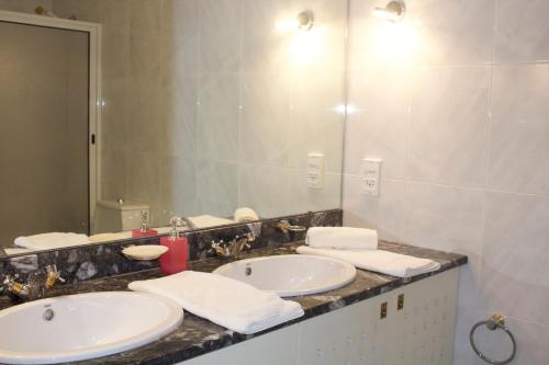 a bathroom with two sinks and a large mirror at Casino Figueira Prime Apartment in Figueira da Foz