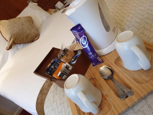 a hotel room with a bed with a table with a blender at Best Western Homestead Court Hotel in Welwyn Garden City