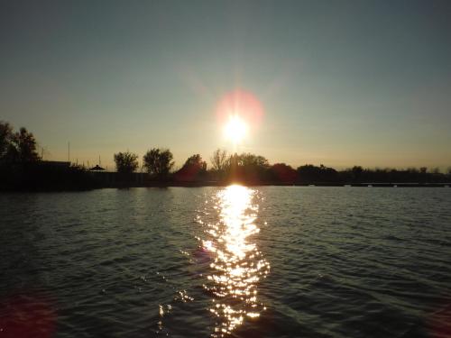 a sun setting over a large body of water at Pfahlbau Sunset I Toplage Elektroboot inklusive in Rust