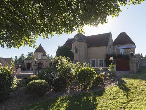 uma casa grande com um quintal com arbustos em frente em Gorgeous manor in the Auvergne with private pool em Meaulne