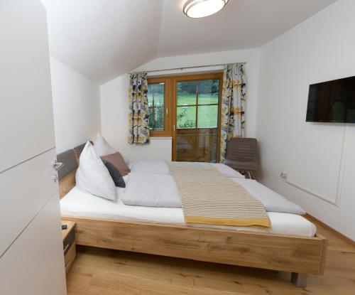 a bedroom with a bed and a window at Oberschartlhof in Flachau