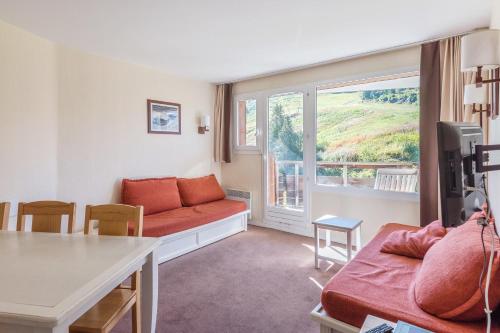 - un salon avec un canapé rouge et une fenêtre dans l'établissement Residence Le Sepia - maeva Home, à Avoriaz