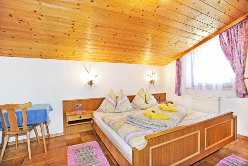 un grande letto in una camera con soffitto in legno di Ferienwohnungen Haus Sonnenschein a Flachau