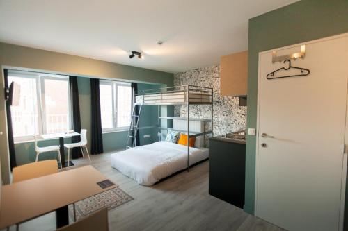 ルーヴェンにあるSmartflats - Leuvenの二段ベッド1組、デスクが備わる小さな客室です。