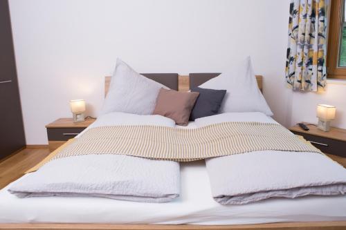 a bedroom with a bed with white sheets and pillows at Oberschartlhof in Flachau