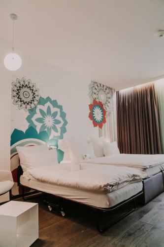 a bedroom with two beds with flowers on the wall at Hotel & Restaurant Heyligenstaedt in Gießen