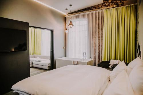a bedroom with a bed and a tub and a sink at Hotel & Restaurant Heyligenstaedt in Gießen