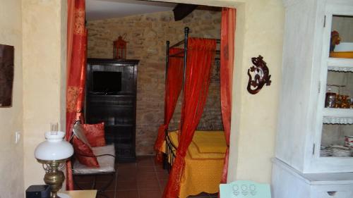 a room with a bedroom with a bed and red curtains at Le Mazet in Remoulins
