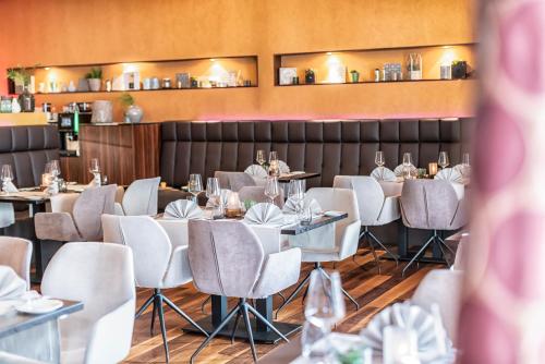 a dining room with white tables and chairs at Hotel Sonne in Rheda-Wiedenbrück