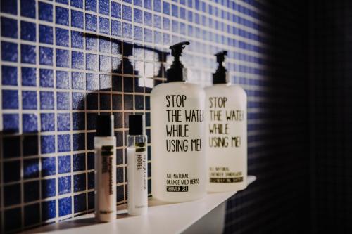 a bathroom with three bottles of soap on a shelf at Hotel & Restaurant Heyligenstaedt in Gießen