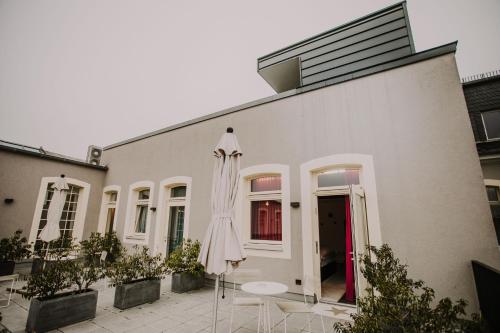 a white building with a table and an umbrella at Hotel & Restaurant Heyligenstaedt in Gießen